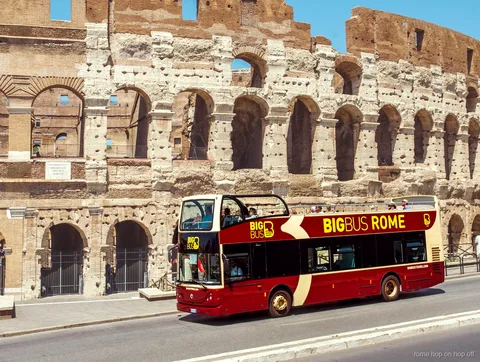 Autobús descubierto de dos pisos del bus turístico de Roma Big Bus pasando por el Coliseo