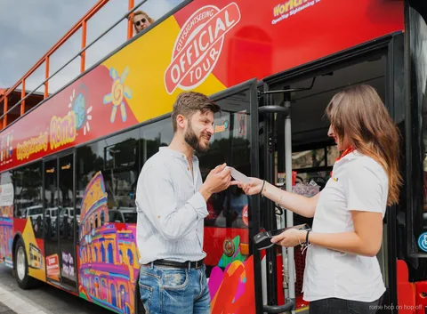 Pasajeros con auriculares en el bus turístico de Roma City Sightseeing