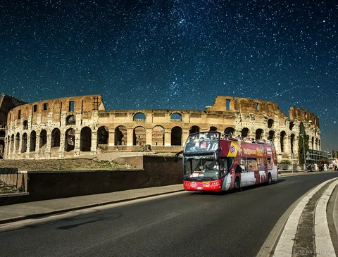 Otwarty piętrowy autobus na nocnej wycieczce hop-on hop-off Rzym
