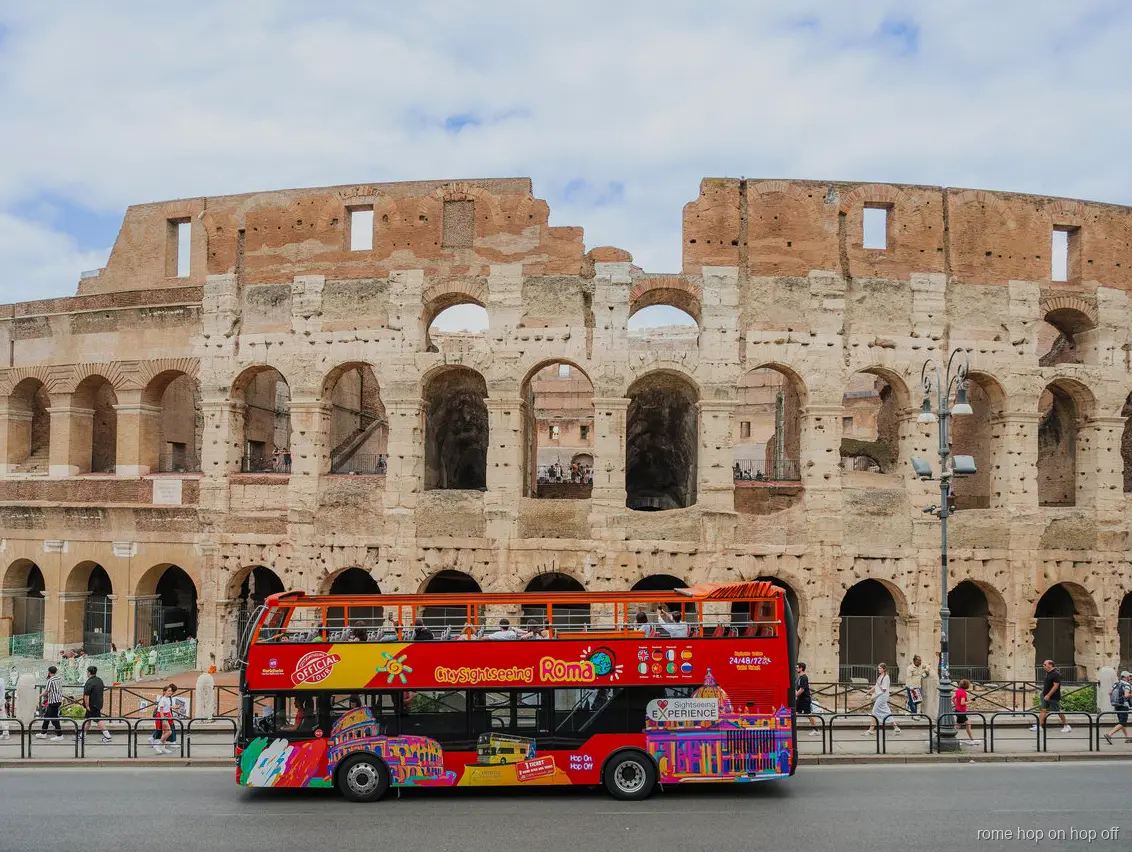Rome City Sightseeing hop-on hop-off bus on its open-top loop near the Colosseum