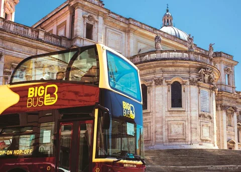 Rome hop-on hop-off bus and boat combo cruising the Tiber near a historic bridge